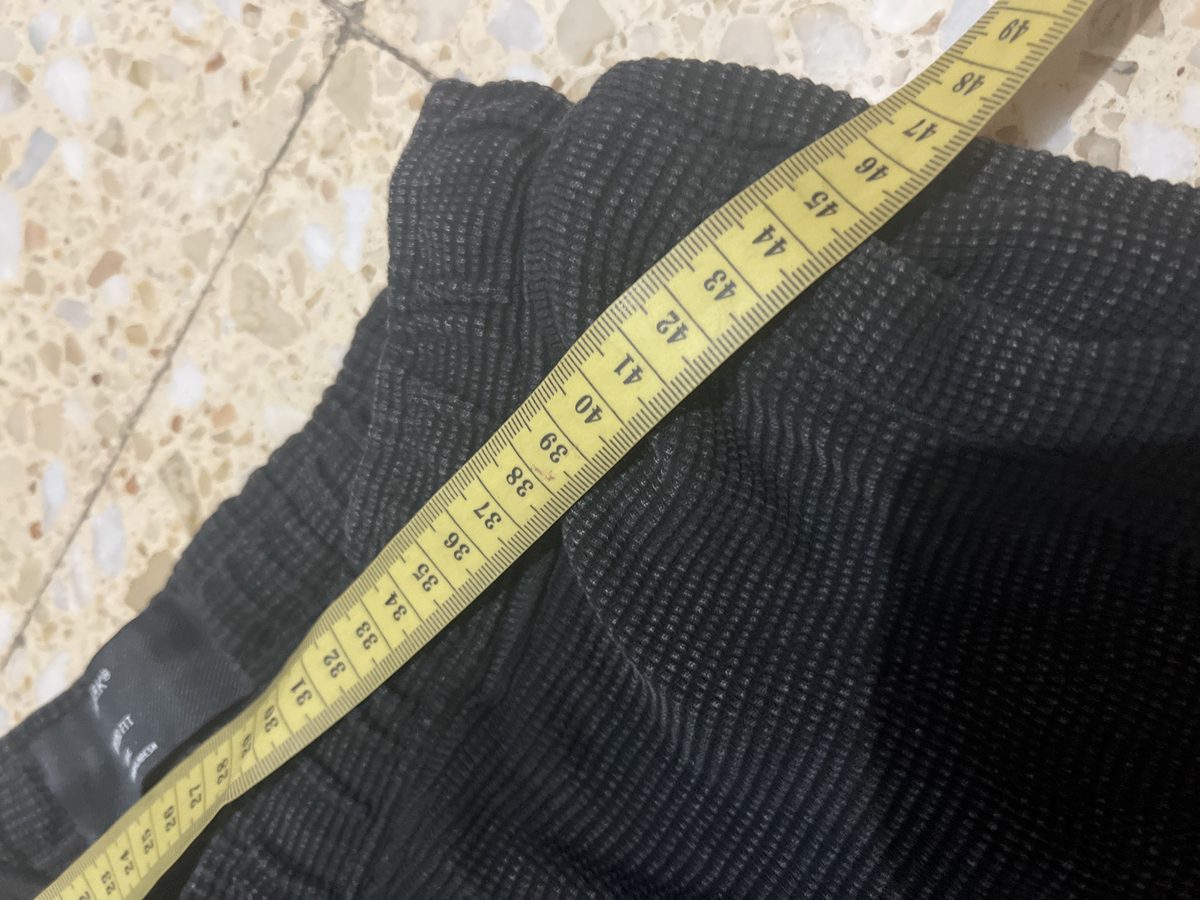 Una cinta métrica sobre el pantalón midiendo el largo