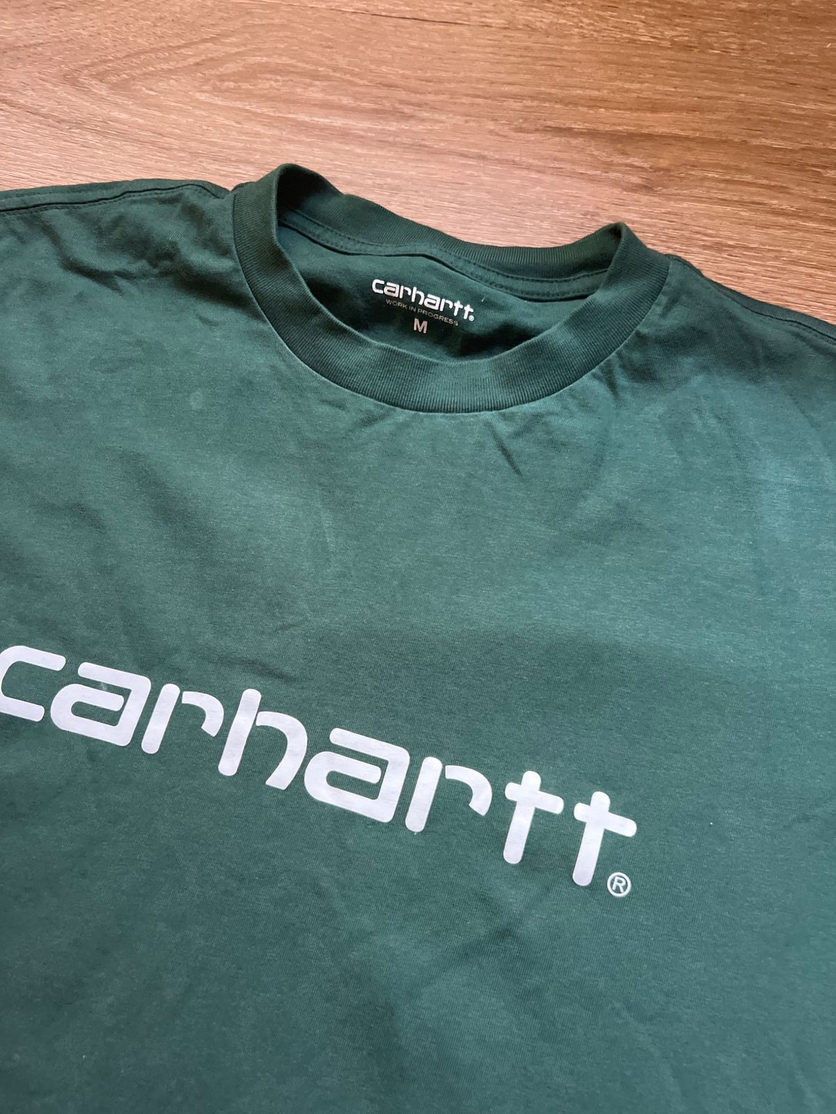 La etiqueta y el cuello de la camiseta verde Carhartt